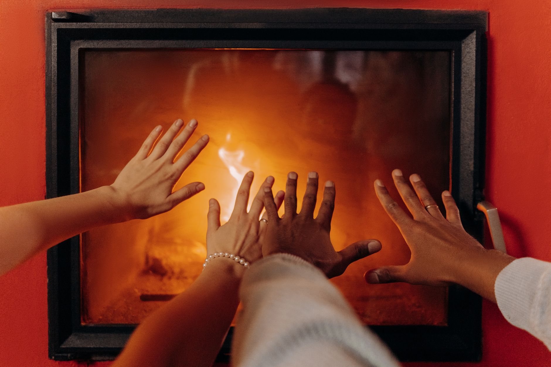 Gros plan sur des mains se réchauffant près d'une cheminée confortable, rayonnant de chaleur et de confort.