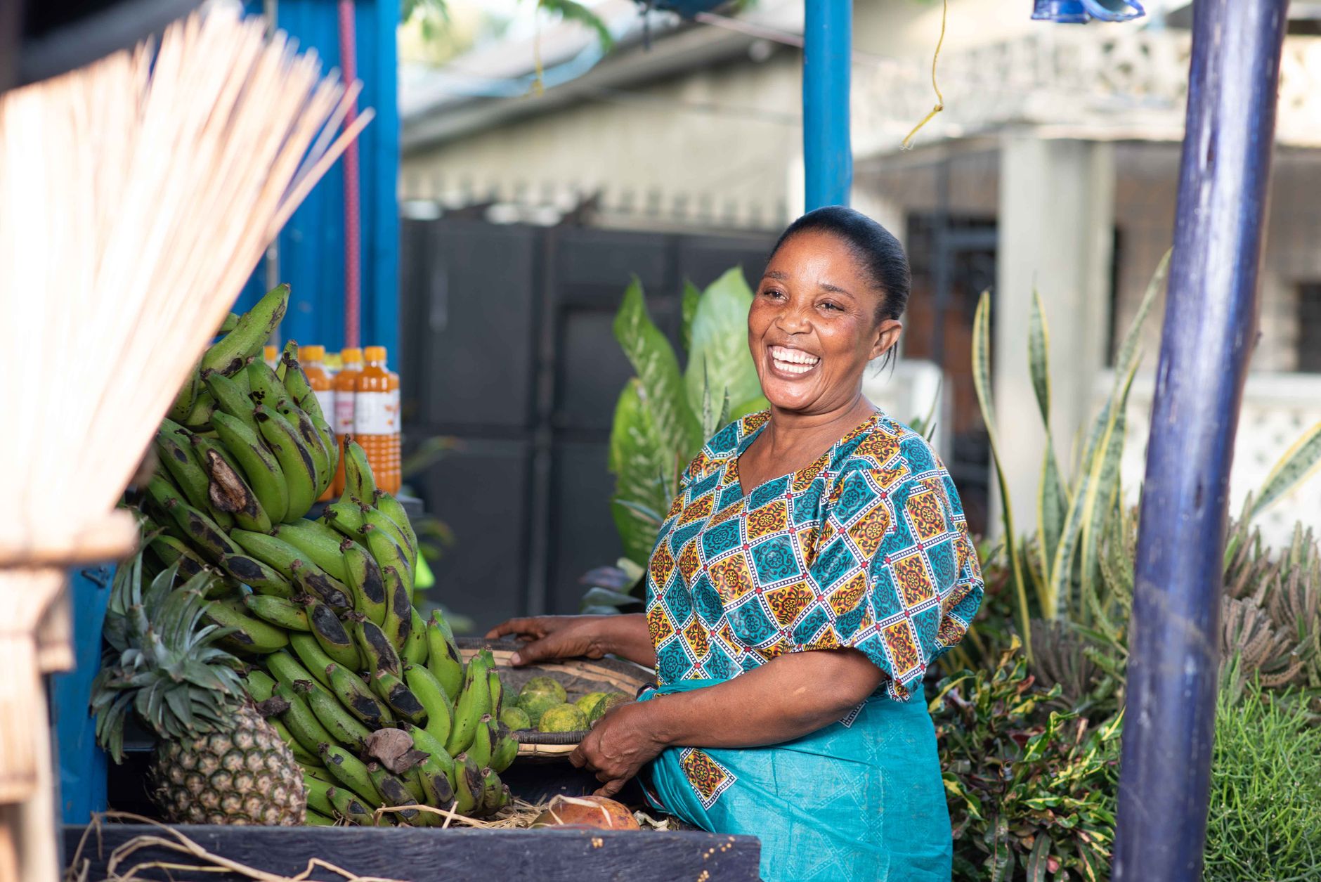 A joyful vendor selling fresh bananas and pineapples at a local market in Dar es Salaam, Tanzania.